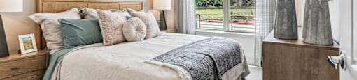 a bedroom with a bed and a large window