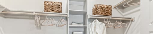 a small laundry room with a white sink and a closet with a rack for towels