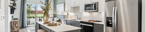 a kitchen with stainless steel appliances and a large island with stools