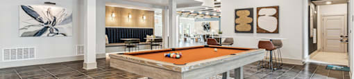 a pool table in a clubhouse with a chandelier