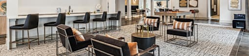 a large lobby with chairs and tables and a bar