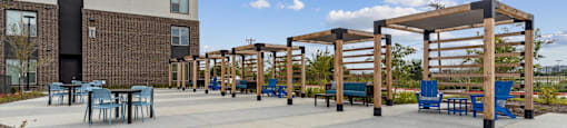 a patio with tables and chairs outside of a building