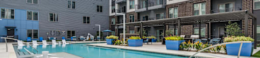 an apartment swimming pool in front of an apartment building