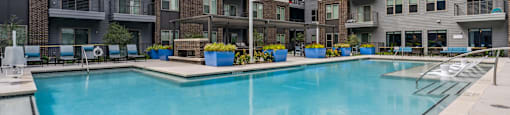 an apartment swimming pool in front of an apartment building