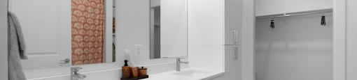 A bathroom with a sink, mirror, and cabinets.