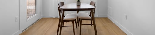 A dining room with a table and chairs.