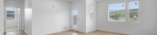 A large empty room with wooden floors and white walls.
