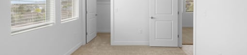 A room with white walls and carpeted floor.