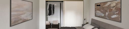 a bedroom with a bed and a sliding door to a closet