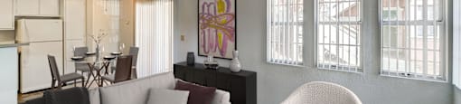 a living room with a couch and a chair and a kitchen with a table