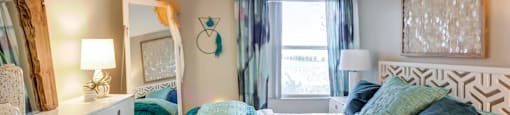 a bedroom with a bed and a dresser with a mirror at Fusion Apartments, Orlando