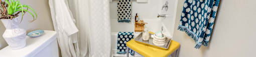 a bathroom with a white toilet and a shower with a blue and white shower curtain at Fusion Apartments, Orlando Florida