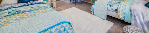 a bedroom with two beds and a desk with a chair at Fusion Apartments, Orlando, 32818