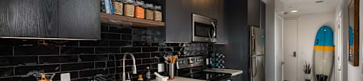 a kitchen with dark cabinets and a white counter top at Burano, Long Beach, CA
