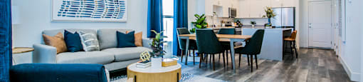 a living and dining room area with a couch a table and chairs and a kitchen in theat Townes at Peace Way, Las Vegas