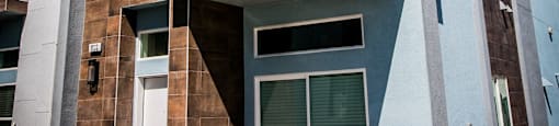 a building with a white door and a brown and white brick facadeat Townes at Peace Way, Las Vegas, 89147