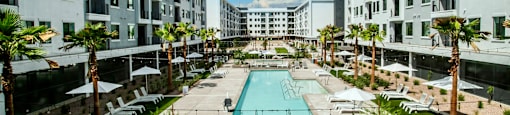 an apartment building with a pool in the middle of it
