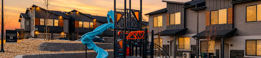 A playground with a blue slide and a red and black structure.