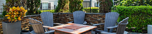 A patio with a table and chairs surrounded by trees.