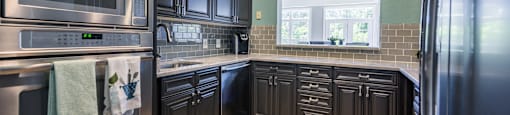 Kitchen with brown cabinets at The Lex at Brier Creek, Morrisville, North Carolina