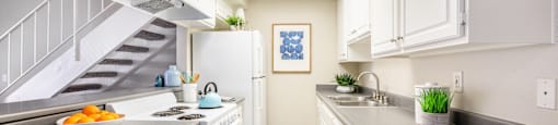 a kitchen with white cabinets and a white stove top oven