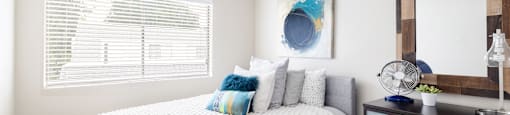 a bedroom with a large bed and a dresser with a mirror