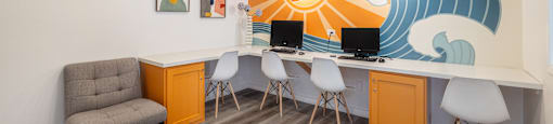 a room with a desk and chairs and a mural on the wall