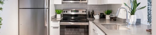 A modern kitchen with stainless steel appliances and white cabinets.