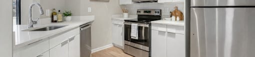 An upgraded modern kitchen with stainless steel appliances and white cabinets.