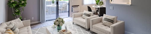 A living room with a white couch, a coffee table, and a mirror on the wall.