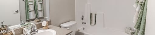 A white bathroom with a toilet, sink, and bathtub.
