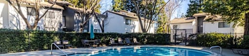 A round above ground pool with a white border and a concrete patio.