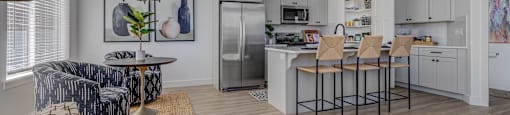 A modern kitchen with a dining area and a living room.