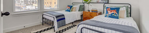 A bedroom with two beds and a painting on the wall.