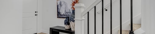 A staircase with a black railing and a white handrail.