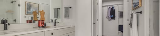 A bathroom with a marble floor mat and a white vanity.