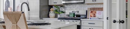 A kitchen with a white countertop and grey cabinets.