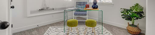 A room with a white rug and a green stool.