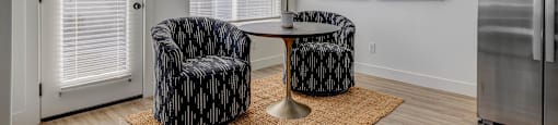 A living room with two chairs and a table.