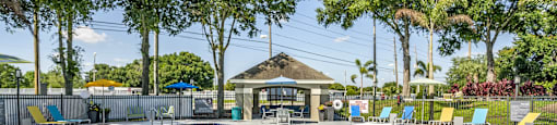 a resort style pool with lounge chairs and a gazebo at Fusion Apartments, Orlando
