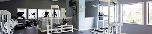 a gym with weights machines and windows