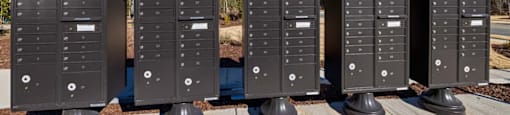 a row of mailboxes sitting on a sidewalk at Ashford Townes Apartments, North Carolina, 27526