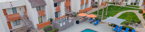 aerial view of the pool with lounge chairs and umbrellas at Sierra Pines apartments in Phoenix, AZ.