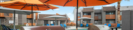 a barbecue grill and umbrellas in a patio with a pool