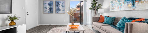 a modern living room with a view of the patio through the arcadia door at Sierra Pines Apartments for rent in Phoenix.