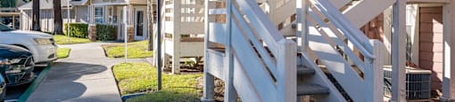 a sidewalk in front of a row of houses with stairs