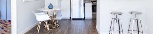 an open kitchen and living room with a bar and stools