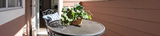a front porch with a table and chairs and a potted plant