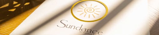 a napkin with a sun dance logo on a table