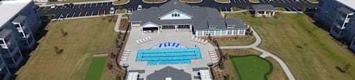 an aerial view of a resort with buildings and a pool